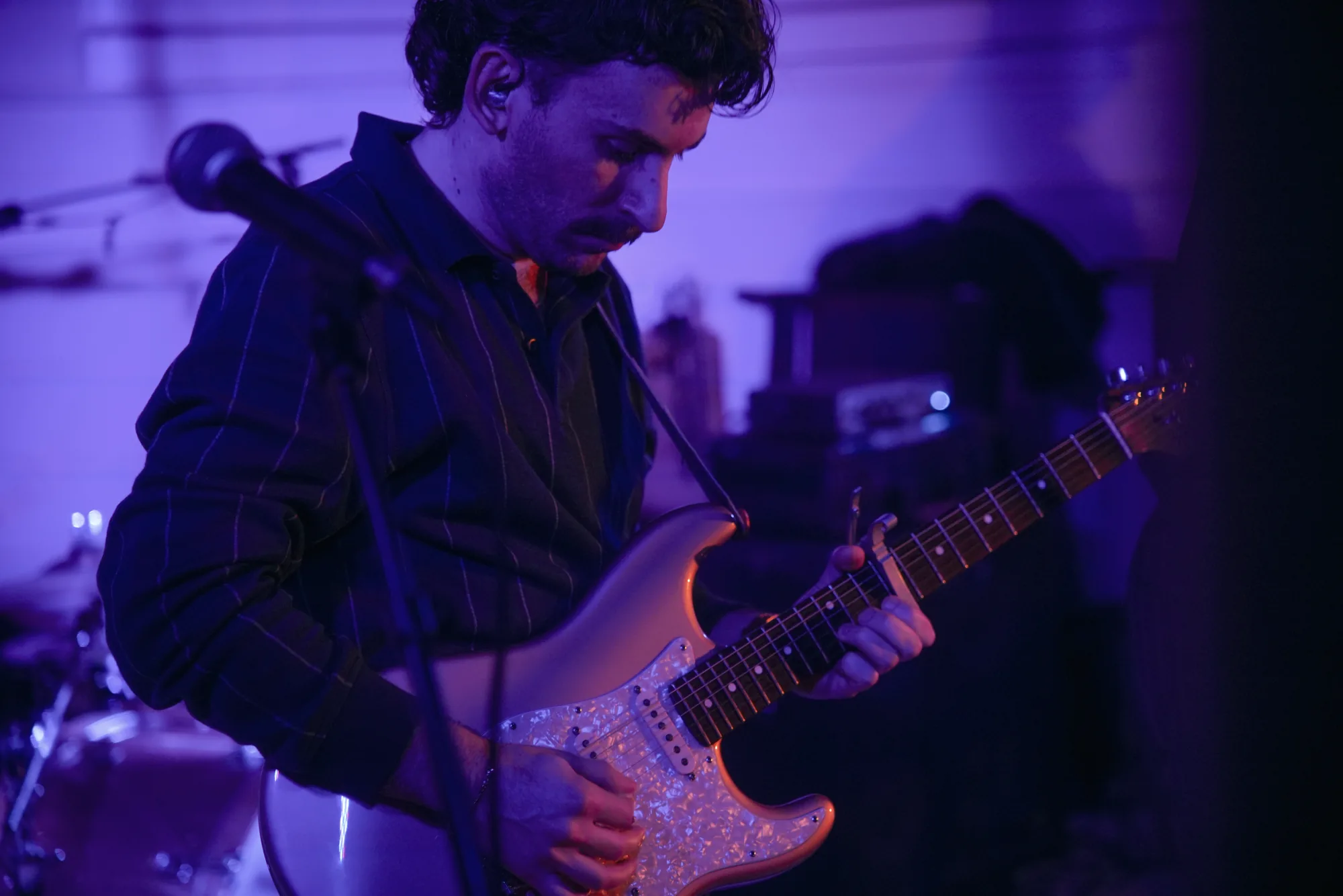 MoonWater guitarist performing under blue stage light